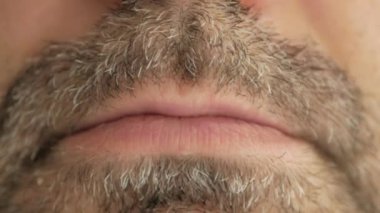 Gri sakallı bir adam virüsten bir hap yutuyor, koronavirüs oluyor ve alaycı bir yüz ifadesi takınıyor. Süper makro yakın çekim.