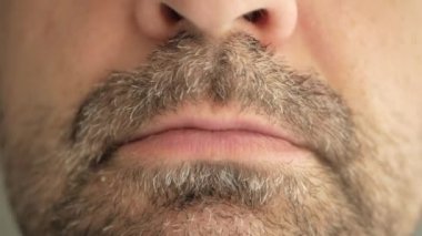 Gri sakallı bir adam virüsten bir hap yutuyor, koronavirüs oluyor ve alaycı bir yüz ifadesi takınıyor. Süper makro yakın çekim.