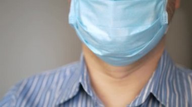 Virüslü üzgün bir adam, kovid 19 ve yüzünde antivirüs koruması maskesi derin nefes alıyor, hızlı nefes alıyor.