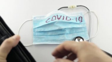 Virüs koruyucu, koronavirüs önleme maskesi, COVID-19, stetoskop, beyaz arka planda para. Ödeme son para. Virüsün tedavisi için. Kriz parası bitti, cüzdan yok. Yakın plan.