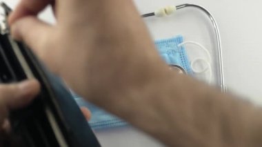 Virüs koruyucu, koronavirüs önleme maskesi, COVID-19, stetoskop, beyaz arka planda para. Ödeme son para. Virüsün tedavisi için. Kriz parası bitti, cüzdan yok. Yakın plan.