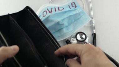Virüs koruyucu, koronavirüs önleme maskesi, COVID-19, stetoskop, beyaz arka planda para. Ödeme son para. Virüsün tedavisi için. Kriz parası bitti, cüzdan yok. Yakın plan.