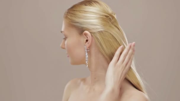 Gorgeous blond girl touching her hair and turn to camera — Stock Video