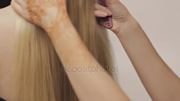 Расчесывание волос на блондинке с длинными волосами. Крупный план — стоковое видео