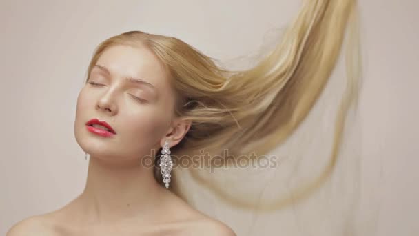 Hermosa chica rubia con el pelo que cae lentamente con los ojos cerrados — Vídeos de Stock