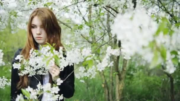 Rothaarige Mädchen in blühenden Blumen — Stockvideo