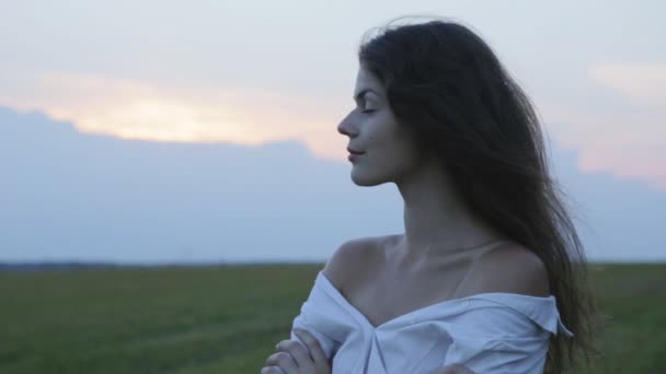 Giovane bella donna lentamente girare la testa al tramonto — Video Stock