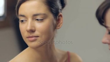 Genç kadının boynunda bir fırça ile makyaj uygulamak makyaj sanatçısı. Yatay kaydırma