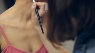 Genç kadının boynunda bir fırça ile makyaj uygulamak makyaj sanatçısı. Yatay kaydırma