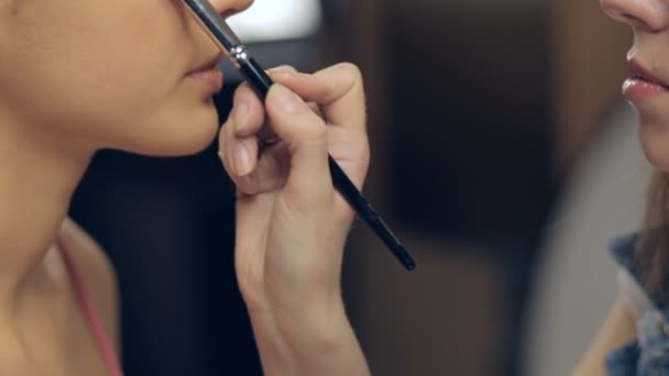 Maquillaje artista aplicar maquillaje con un cepillo bajo los ojos de la mujer joven. Panorama — Vídeos de Stock