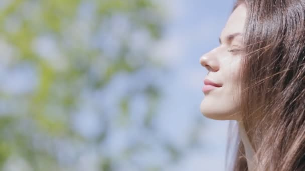 Joven mujer bonita al aire libre. Disfrutando de la luz del sol. Primer plano. — Vídeos de Stock