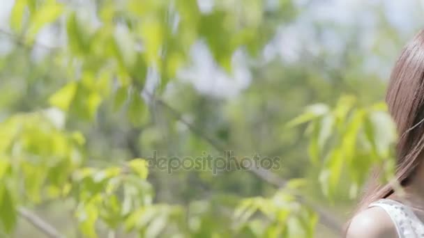 Joven mujer bonita con ramas llenas de hojas verdes — Vídeos de Stock