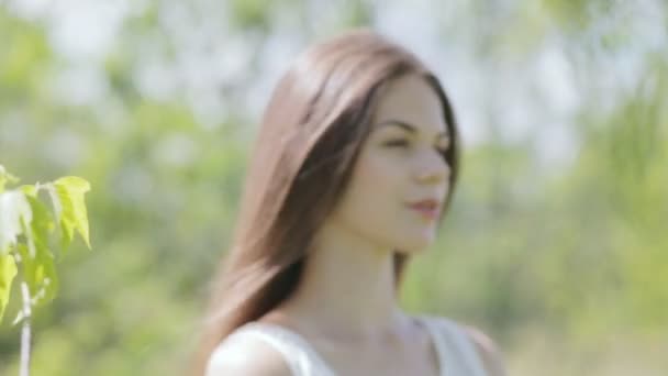 Молодая красивая женщина с ветвями, полными зеленых листьев — стоковое видео