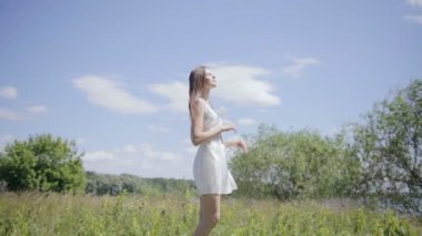 Çayır üzerinde genç güzel kadın. Güneş ışığı zevk