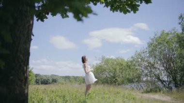 Çayır üzerinde genç güzel kadın. Güneş ışığı zevk