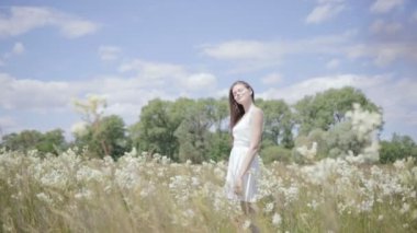 Genç güzel kadın çiçek çayır ortasında. Ağır çekim