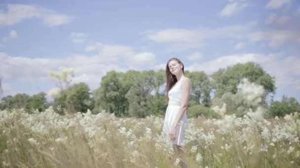 Joven mujer bonita en medio del prado de flores — Vídeos de Stock