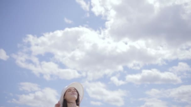 Joven mujer bonita cerca del agua con el cielo lleno de nubes — Vídeos de Stock