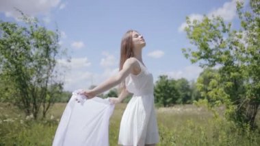 Genç beyaz bez rüzgarla tutan kadın çok. Orta atış