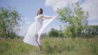 Genç beyaz bez rüzgarla tutan kadın çok. Tam uzunlukta vurdu