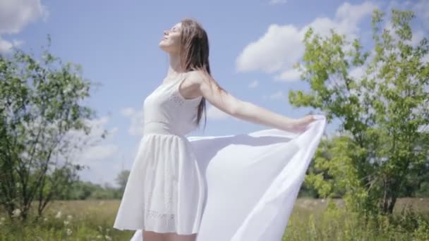 Молода красива жінка тримає білу тканину на вітрі. Середній постріл — стокове відео