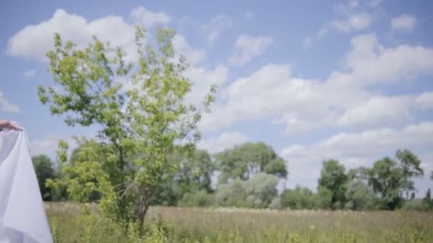 Młode ładne kobietę białym obrusem na wiatr. Średni strzał — Wideo stockowe