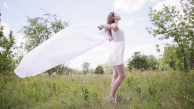 Genç beyaz bez rüzgarla tutan kadın çok. Tam uzunlukta vurdu