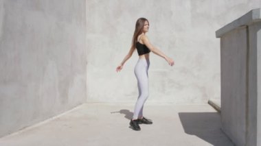 Açık havada etrafında dönen genç kadın dansçı. Ağır çekim