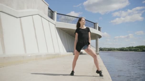 川の近くに立っている若い魅力的な女性 — ストック動画