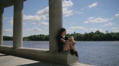 Genç kadın bir kenara Nehri seyir yakınındaki oturuyordu güzel