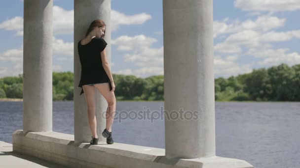 Jeune jolie femme debout près de la rivière — Video
