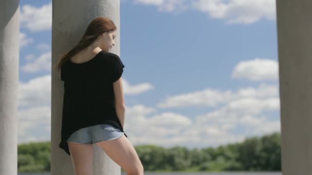 Νεαρή όμορφη γυναίκα που στέκεται κοντά στον ποταμό — Αρχείο Βίντεο