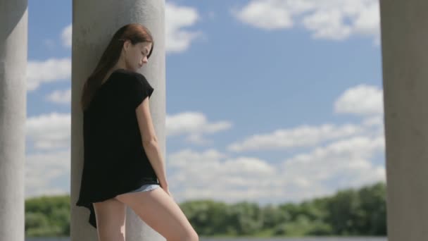 Молода красива жінка стоїть біля річки — стокове відео