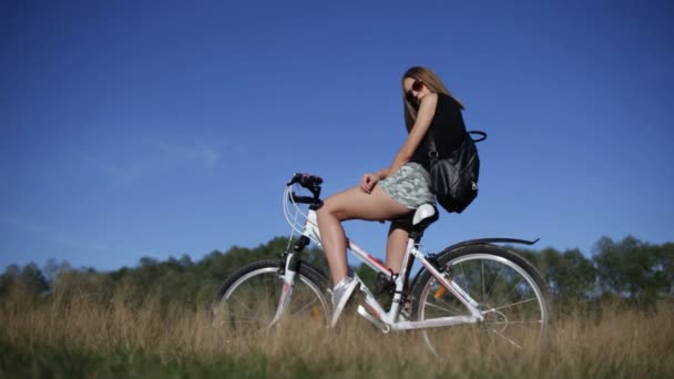 Mujer joven con bicicleta — Vídeo de stock