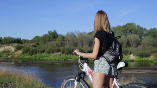 Mujer joven con bicicleta — Vídeo de stock