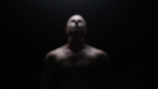 Бодібілдер позує в темряві — стокове відео