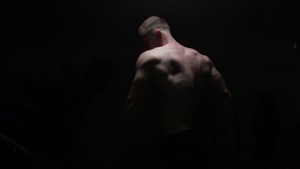 Kroppsbyggare poserar i mörkret — Stockvideo