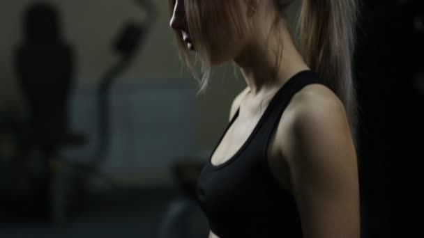 Тренер помогает молодой женщине в спортзале — стоковое видео