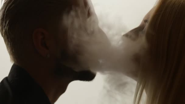Женщина целует мужчину в дым. Петля — стоковое видео