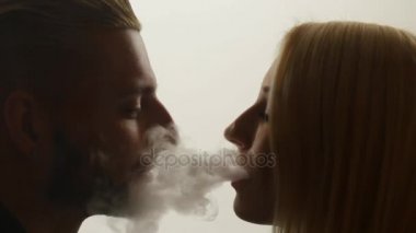 Kadın duman öpücük adama veriyor.