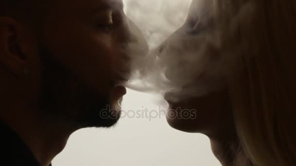 Мужчина целует женщину в дым. Петля — стоковое видео