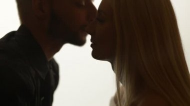 Kadın duman öpücük adama veriyor.