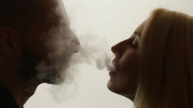 Kadın duman öpücük adama veriyor.