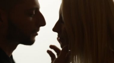 Kadın duman öpücük adama veriyor.