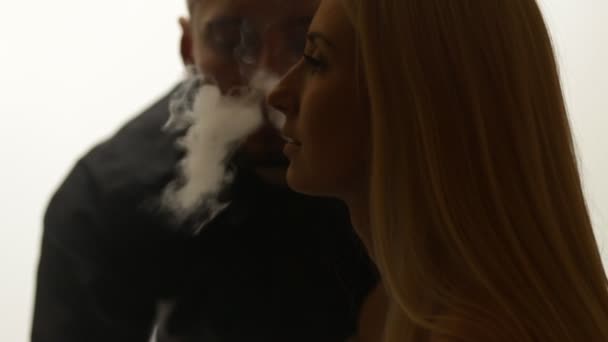 Man geeft rook kus aan vrouw — Stockvideo