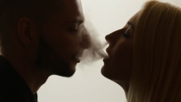 Woman gives smoke kiss to man — Stock Video