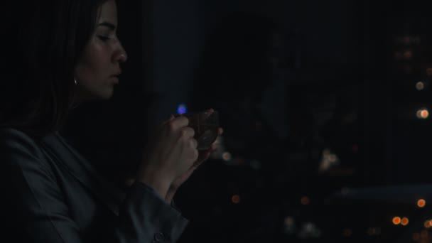 Mulher no escuro segurando copo — Vídeo de Stock