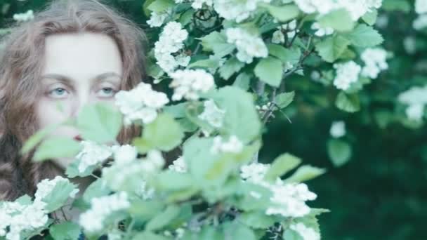 Young redhead girl in spring flowers — Stock Video