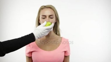 Sarışın kadın ısırıkları armut beyaz eldiven ile elden