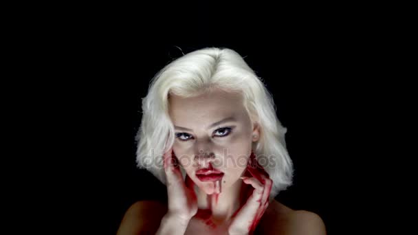 时尚的金发碧眼的手和脸 年轻的金发女郎在脸上摆着黑色的血迹 — 图库视频影像
